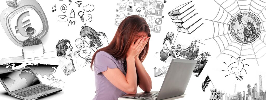 A frustrated woman at a computer thinking of all the things she needs to do.
